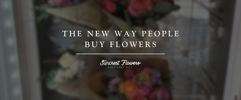 Customers purchasing fresh seasonal bouquets from the Suncrest Flowers flower vending machine at Trolley Square in Salt Lake City as part of a modern flower shopping experience.
